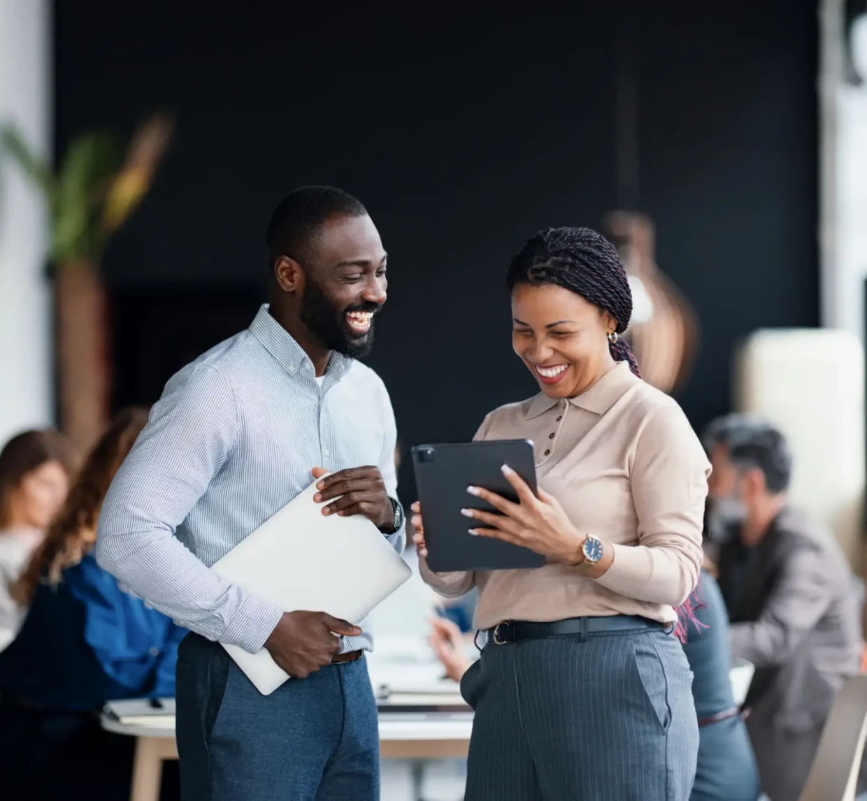 Colleagues discussing work on a tablet