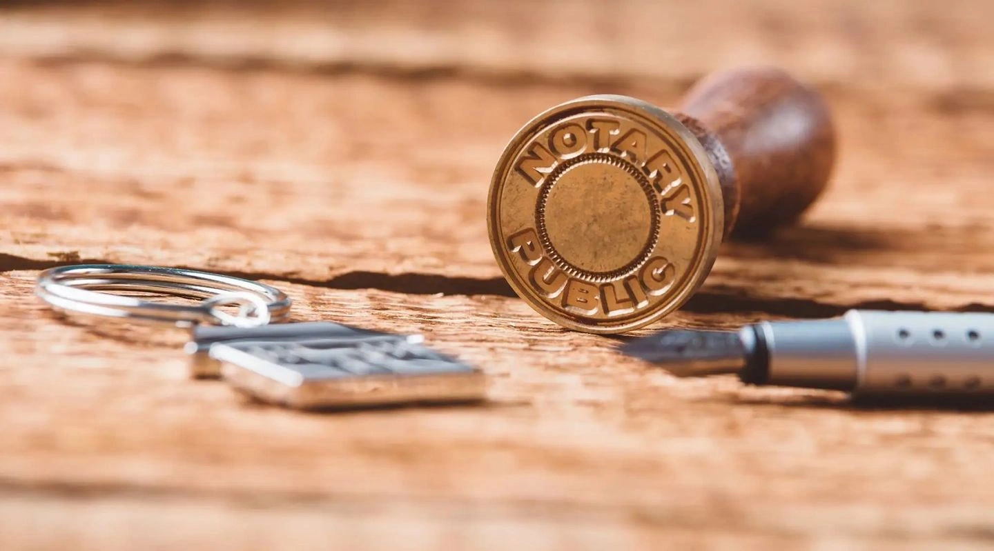 A close-up of a wax seal stamp and wax on paper.