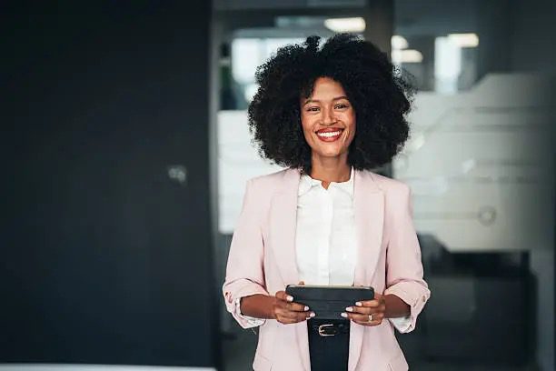 Smiling professional holding a tablet in office.